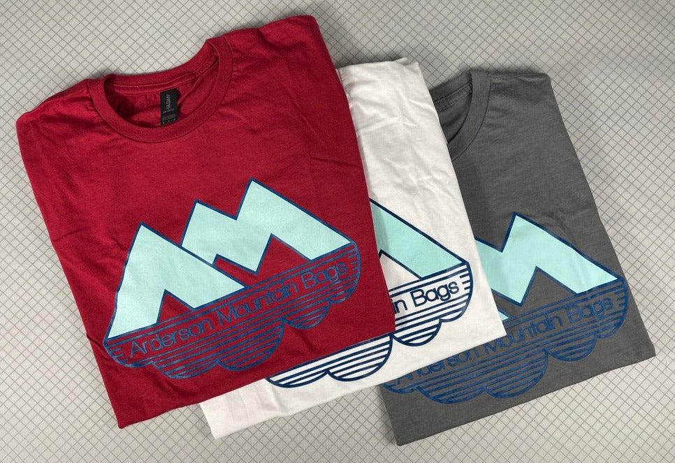  t-shirts in red, white, and gray with a logo on a textured surface